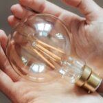 Innovation Boost - Unrecognizable woman demonstrating light bulb in hands
