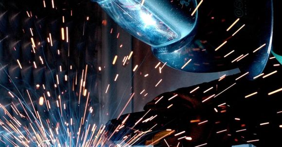 Manufacturing - Person in Welding Mask While Welding a Metal Bar